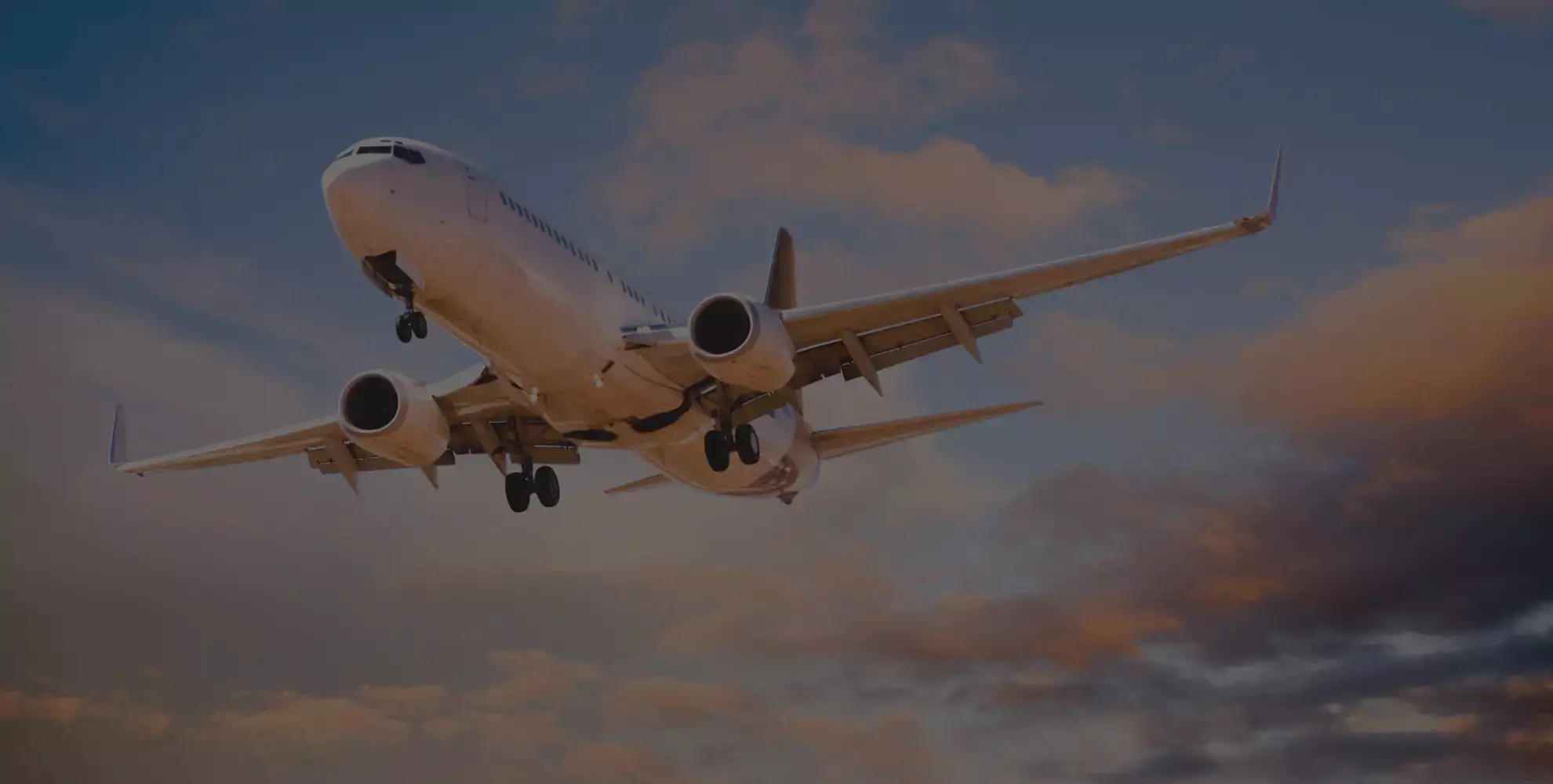 Airplane flying through the sky during sunset with clouds in the background giving international moves from Sharjah