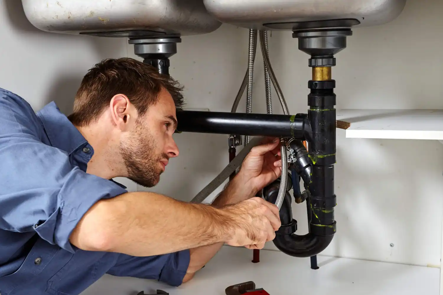 man working under sink for handyman service